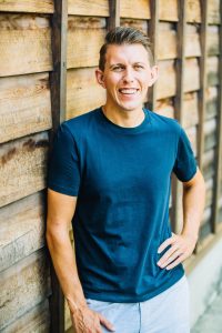 Paul standing against wood wall